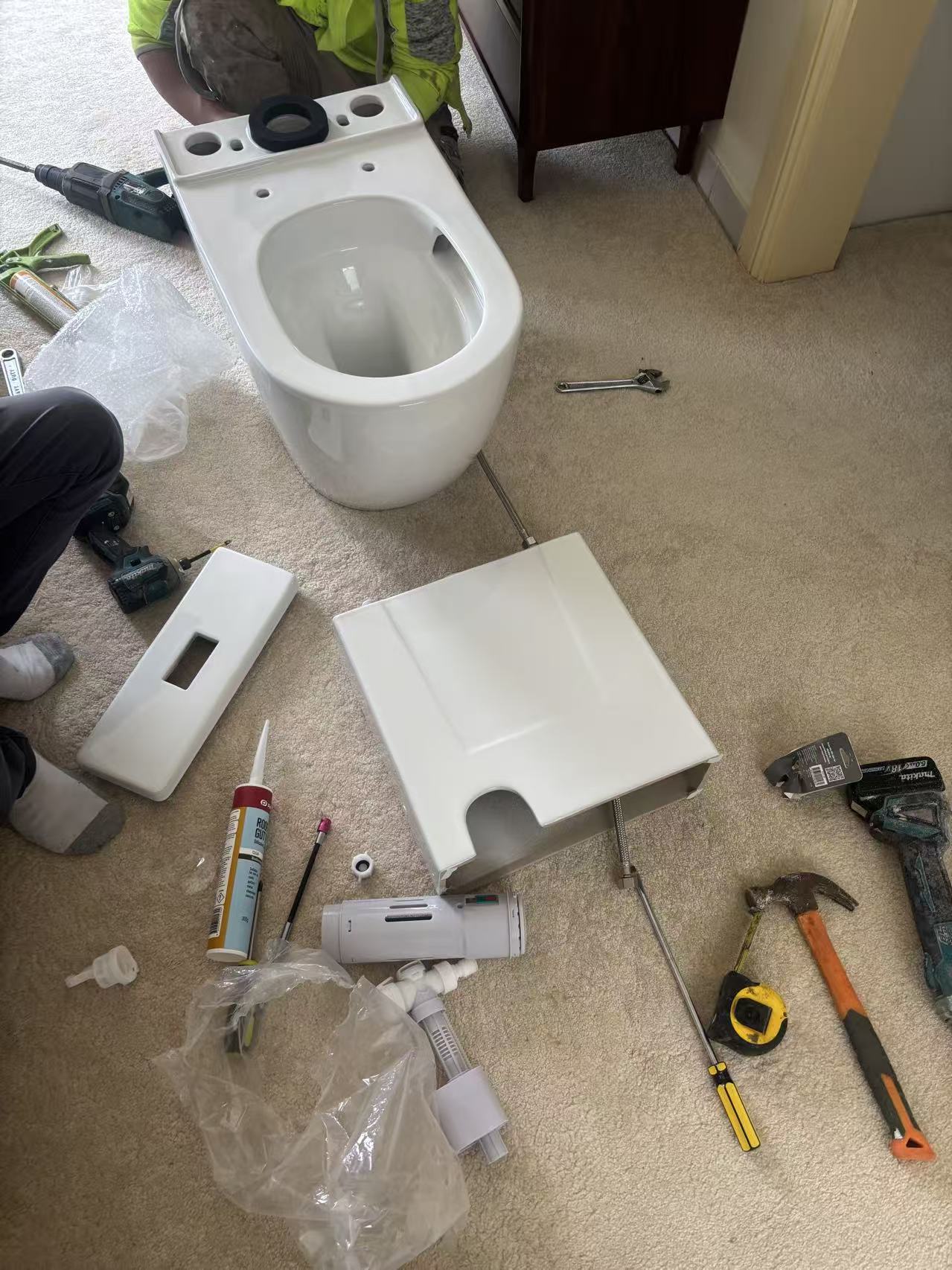 Installer preparing a Noxwell BTWH-3092 toilet suite for a Central Coast motel bathroom replacement project
